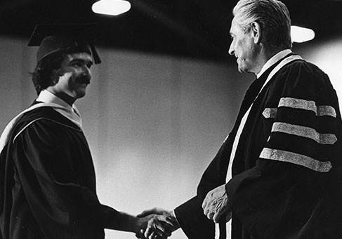 Black and white early convocation photo - student receiving degree