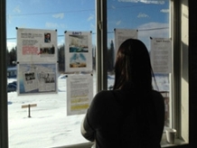 Woman looking at news articles at Shoal Lake 40.