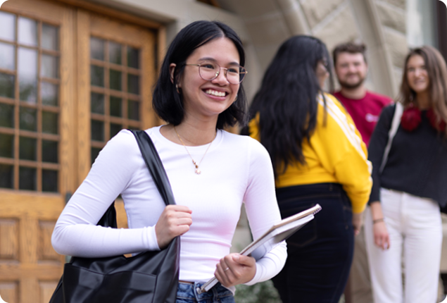 Student smiling on front steps of Wesley Hall