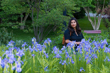 Prof. Zabeen Khamisa with a garden of irises in the foreground