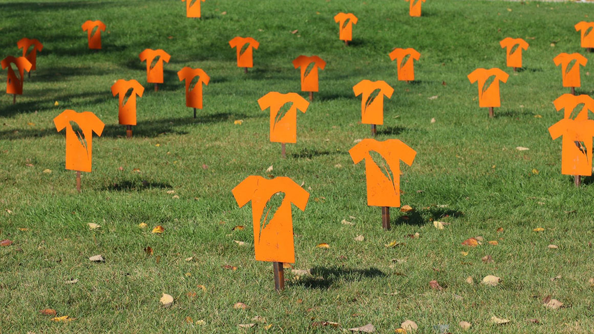 Orange metal Every Child Matters shirts on lawn