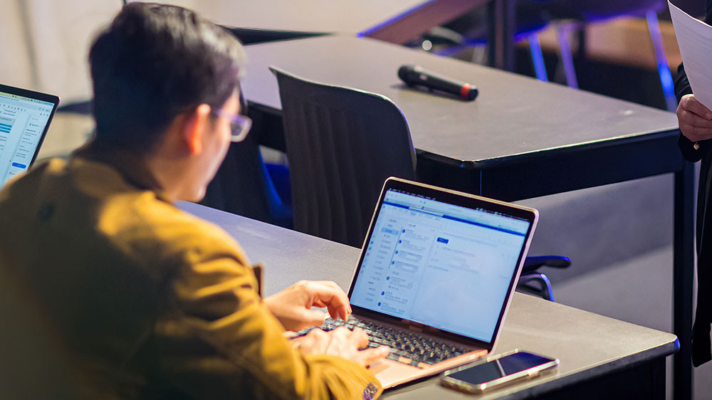 Student in a classroom with a laptop