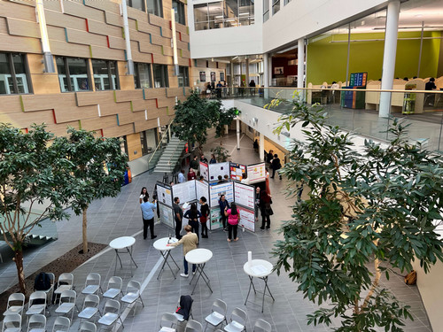 judges, posters and students presenting at the 2023 symposium in the atrium of Richardson